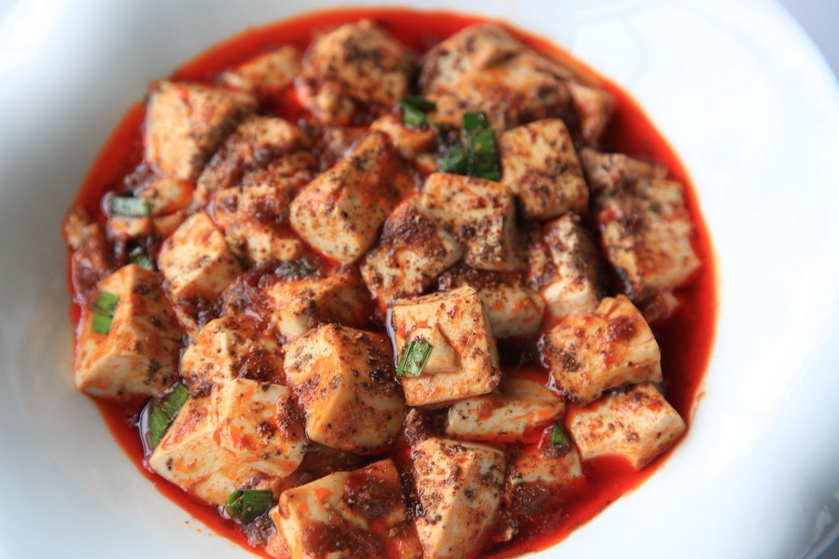 Mapo tofu cubes in red chili oil sauce with Sichuan pepper and scallions